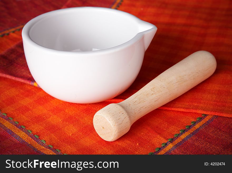 White mortar over a red and orange tablecloth. White mortar over a red and orange tablecloth