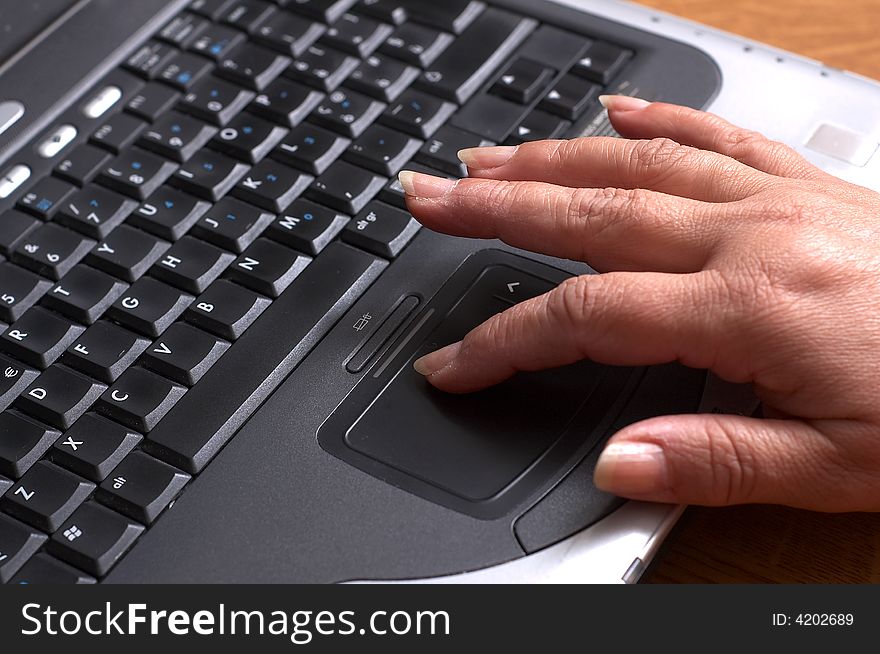 Mid age woman's hands on the keyboard of laptop in the office. Mid age woman's hands on the keyboard of laptop in the office