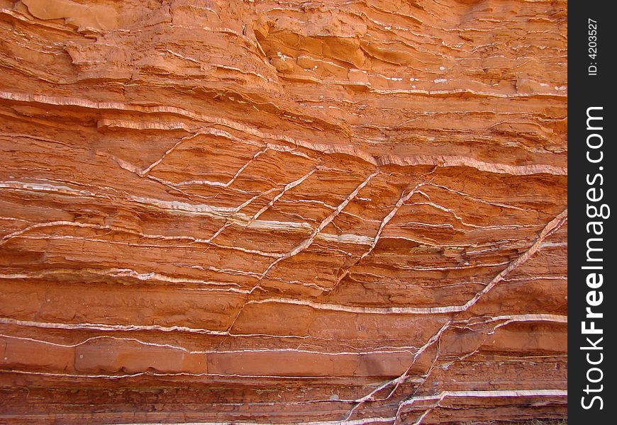Red canyon wall with streaks of white gypsum. Red canyon wall with streaks of white gypsum.