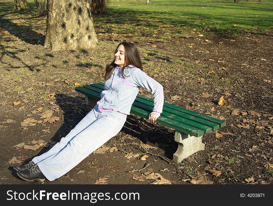 A girl, working out in the park, smiling. A girl, working out in the park, smiling