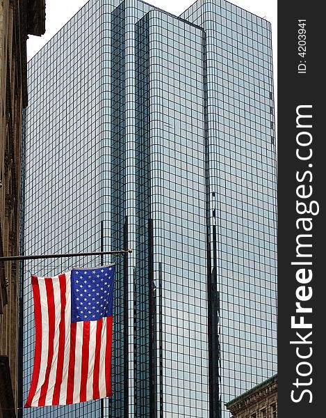 A US flag hanging in front of a large glass skyscraper. Taken in Boston. A US flag hanging in front of a large glass skyscraper. Taken in Boston.