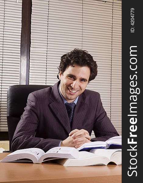 Business man at office with many books