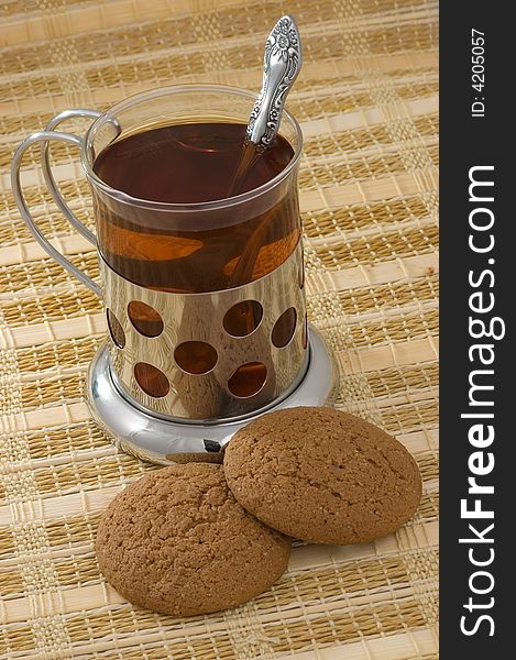 Hot black tea in glass with two cookies. Hot black tea in glass with two cookies