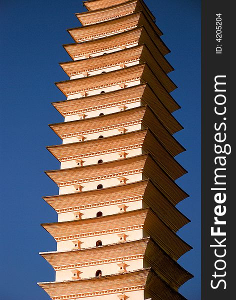 A white pagoda is gilted golden in the morning sun. A white pagoda is gilted golden in the morning sun