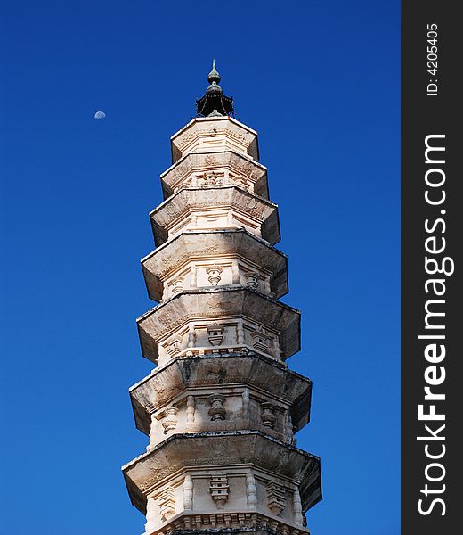 A pagoda and the moon in the velvet blue sky. a building erected as a memorial or shrine.