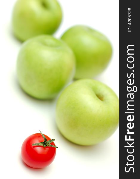 Red tomato and green apples on white