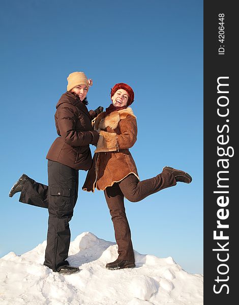 Two young woman posing on snow hill