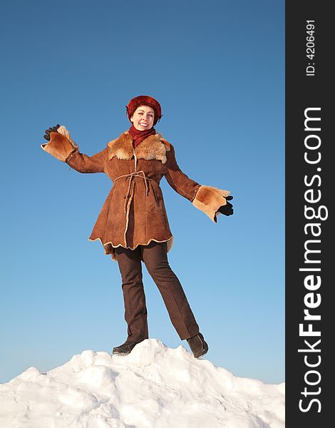 Pretty young woman posing on snow hill