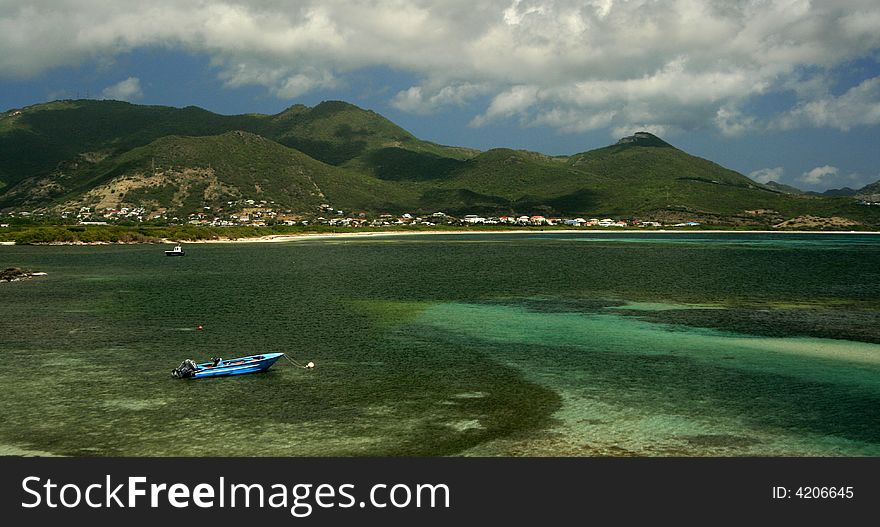 A small boat floats off Coconut Grove looking towards Orient Bay Beach in St. Maarten. A small boat floats off Coconut Grove looking towards Orient Bay Beach in St. Maarten