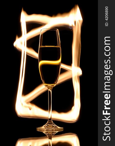 Single champagne glass on black with fire frame