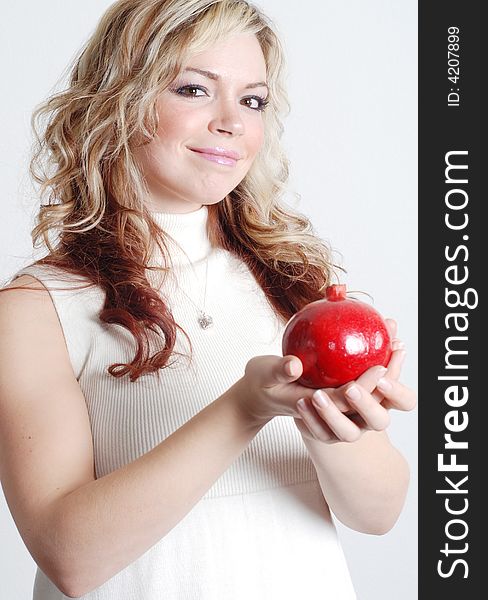 Beautiful woman is holding a fruit in her hands. Beautiful woman is holding a fruit in her hands