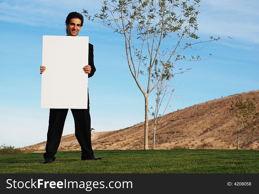 Confident and successful businessman is holding a blank board. Confident and successful businessman is holding a blank board