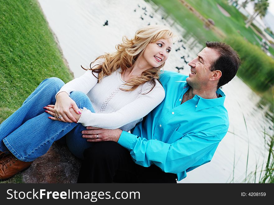 A happy couple smiling in green park environment