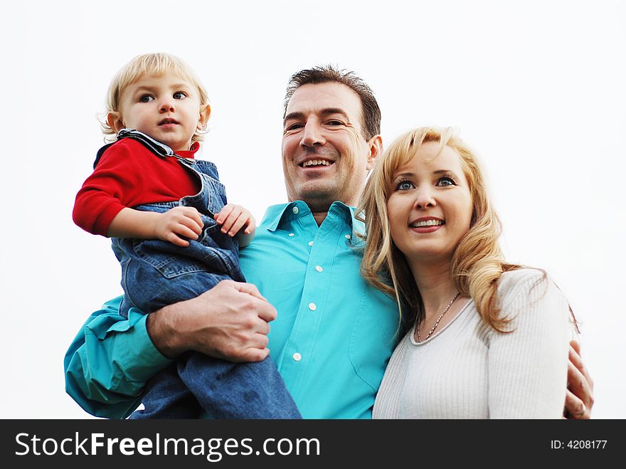 Happy couple with a child enjoying their time together(The man is in focus, woman and the kid is slightly out of focus)