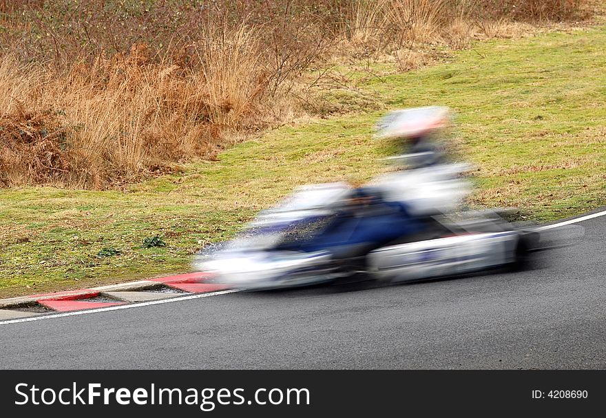 Speeding go-kart blur on the racing line apex. Speeding go-kart blur on the racing line apex