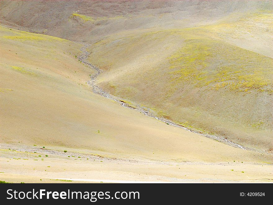 Small stream in Tibet seen from a mountain pass at an altitude of about 5000 meter