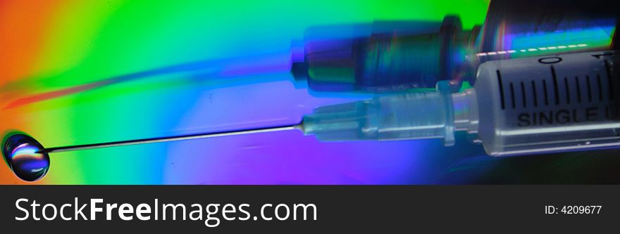 Syringe close up on an iridescent background of a reflecting surface