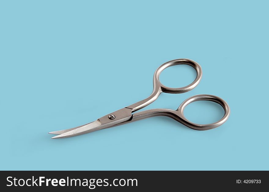 Manicure scissors isolated on blue background
