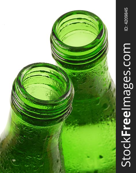 Bottled water in green, condensation-covered bottles; differential focus