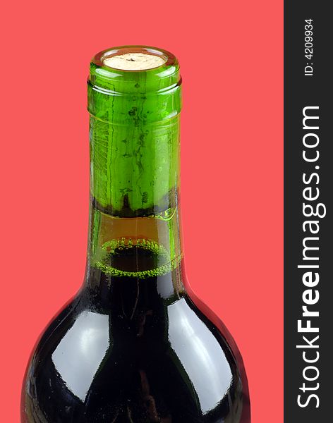 Detail of green wine bottle; isolated on red ground