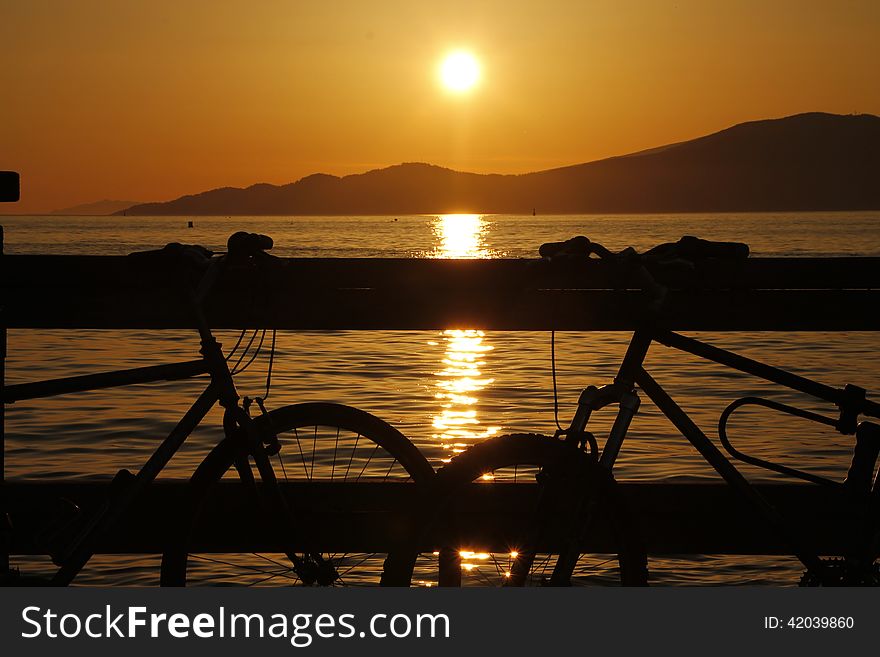 Vancouver Bay sunset with two bicycles in foreground. Vancouver Bay sunset with two bicycles in foreground
