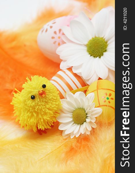 Easter motive-little chick,white flover,easter eggs on yellow and orange feathers.