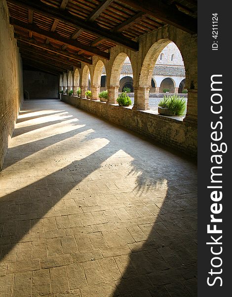 Morning sun streaming through the arches of the abbey courtyard - portrait view. Morning sun streaming through the arches of the abbey courtyard - portrait view