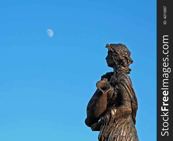 Photo of the women sculpture looking at the moon