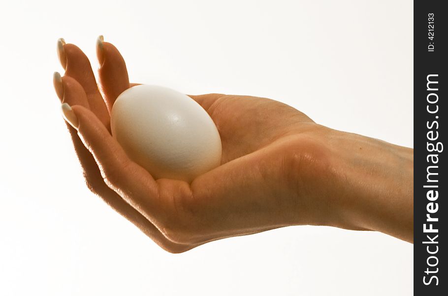 An egg in the palm of a female hand. An egg in the palm of a female hand