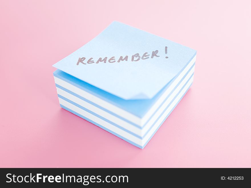 Pile of sticky notes with text over a pink table