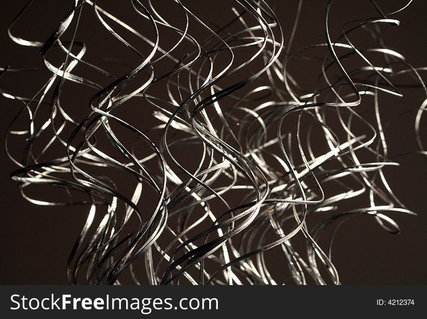 Silver swirling grass like decorations arranged in a vertical fashion. Silver swirling grass like decorations arranged in a vertical fashion.