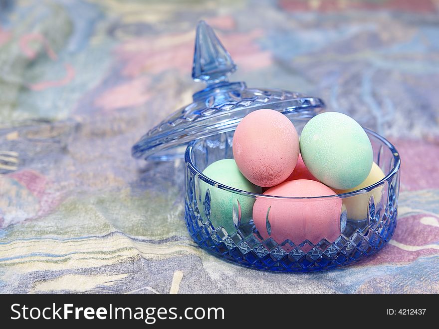 Pastel easter eggs in blue cut crystal candy dish. Pastel easter eggs in blue cut crystal candy dish