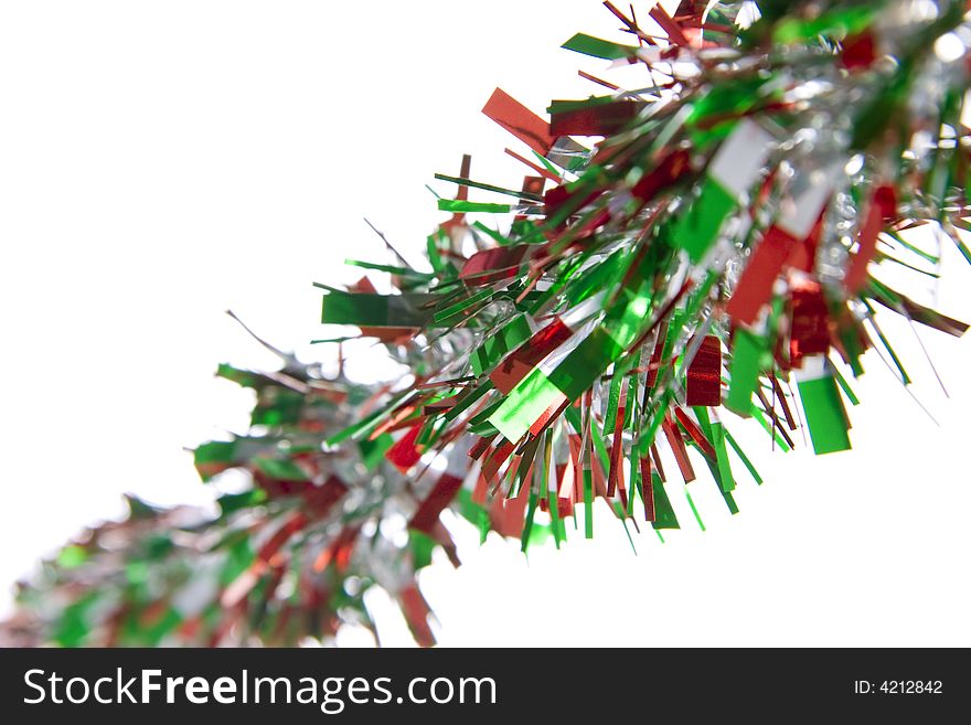 Red and green holiday tinsel on white background