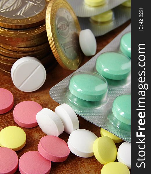 Assorted colorful pills with coins. Assorted colorful pills with coins