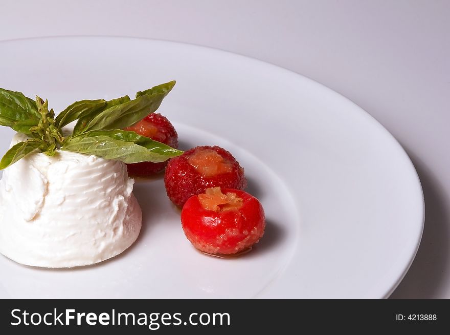 A detailed shoot of an isolated italian cheese ricotta whit basil red hot chili peppers