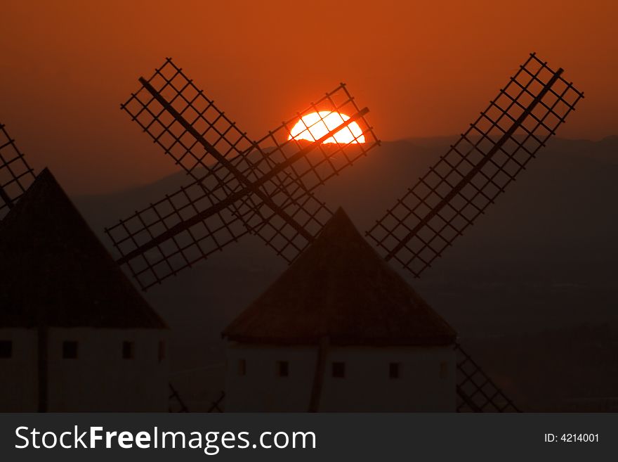 Sunset between the arms of windmills. Sunset between the arms of windmills