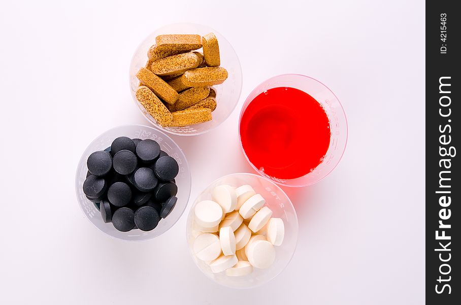 Different medication in different forms in a cup.