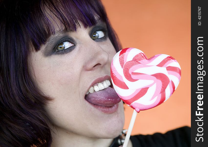 Close-up of an Alternative Girl with a Heart Lollipop