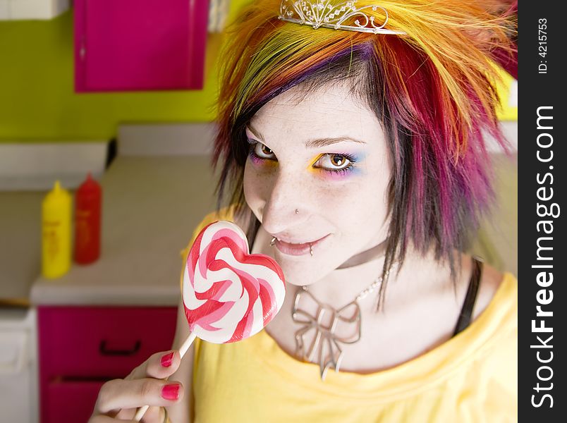 Alternative Girl in a Colorful Kitchen with a Heart Lollipop. Alternative Girl in a Colorful Kitchen with a Heart Lollipop