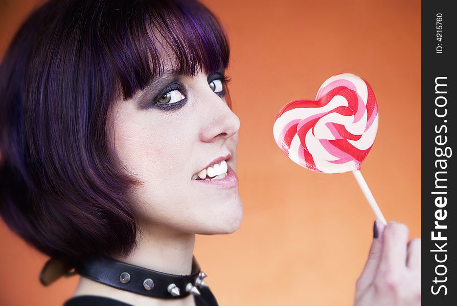 Close-up of an Alternative Girl with a Heart Lollipop