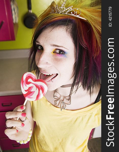 Alternative Girl in a Colorful Kitchen with a Heart Lollipop. Alternative Girl in a Colorful Kitchen with a Heart Lollipop