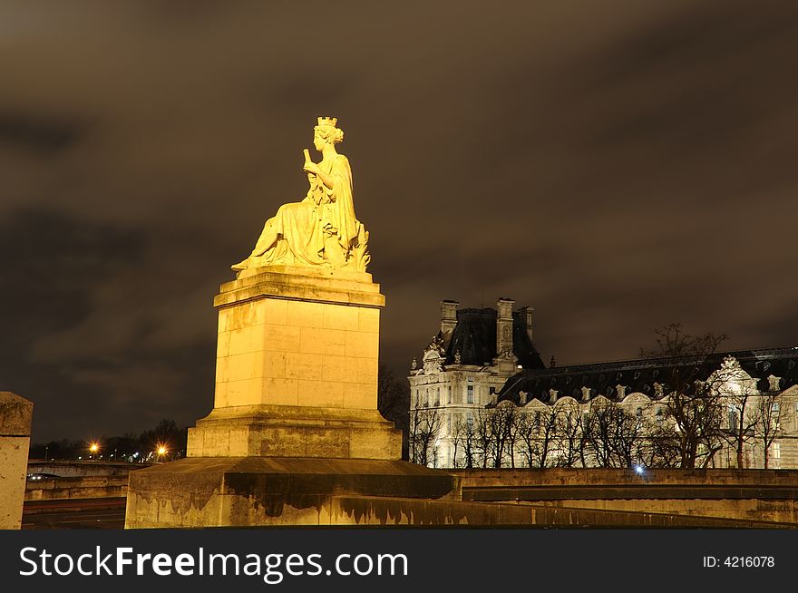 Stone statue and Night view of the Conciergerie (old medieval jailhouse). Stone statue and Night view of the Conciergerie (old medieval jailhouse)