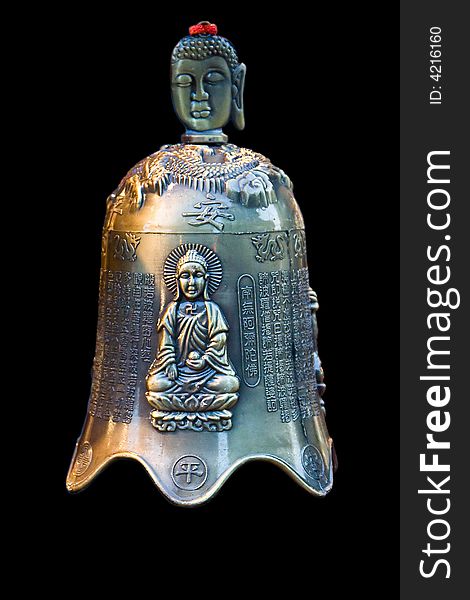 A bronze bell with Chinese characters and an image of Buddha sitting in the lotus position and the face of Buddha as handle, isolated on black. A bronze bell with Chinese characters and an image of Buddha sitting in the lotus position and the face of Buddha as handle, isolated on black