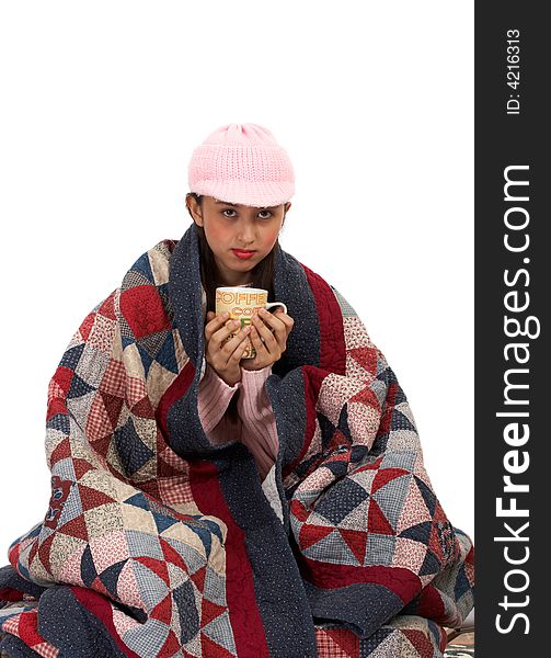 Lady sipping a hot coffee while her body covered wtth quilt