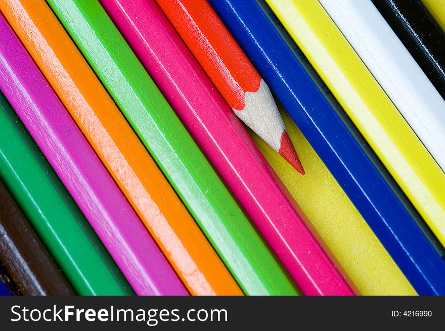 Red pencil crayon isolated from other colorful pencil crayons. Red pencil crayon isolated from other colorful pencil crayons