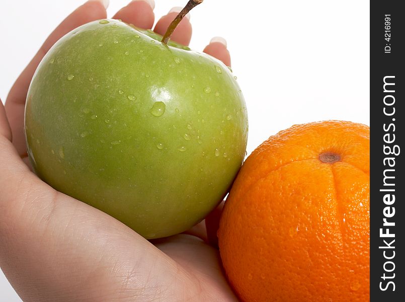 Fresh green apple and orange held by a woman