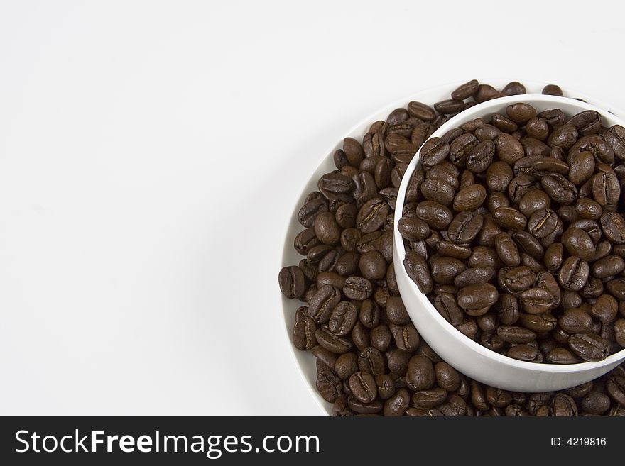 White coffee cup full of coffee beans. White coffee cup full of coffee beans