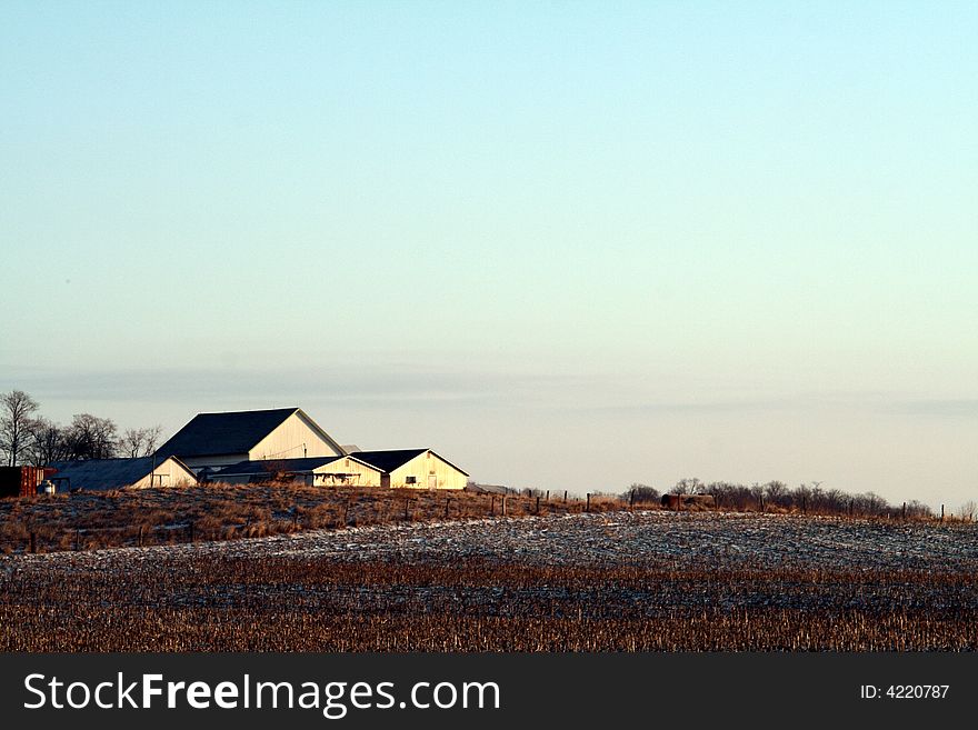 A field with a farmhouse in the distance. A field with a farmhouse in the distance.