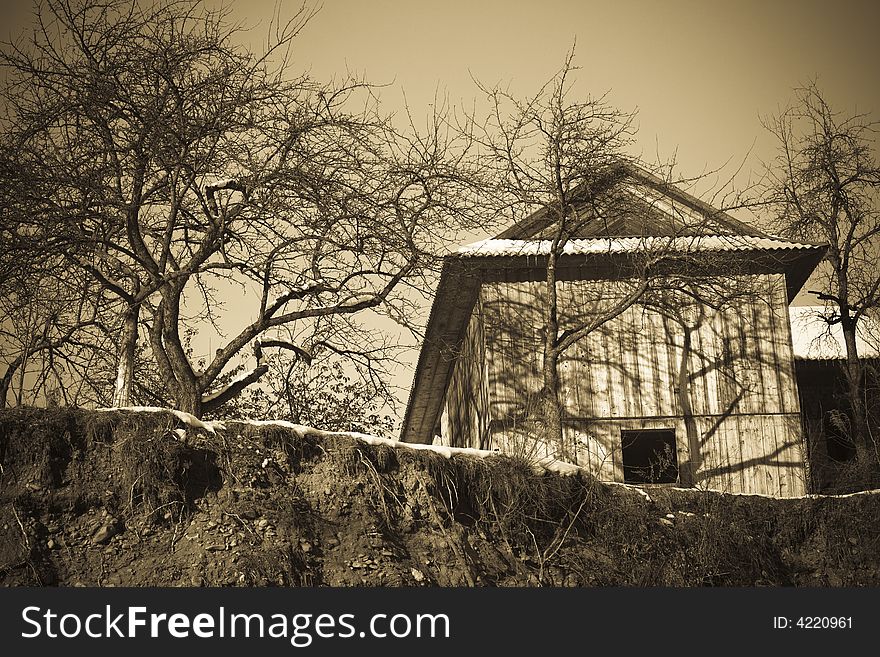 Sepia toned old-fashioned vintage village house with trees. Sepia toned old-fashioned vintage village house with trees