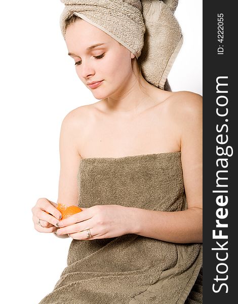 Young woman on a white background  in towel caring for herself. Young woman on a white background  in towel caring for herself